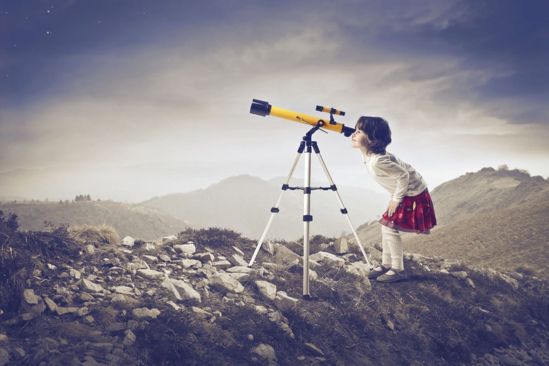 Girl looking through a telescope